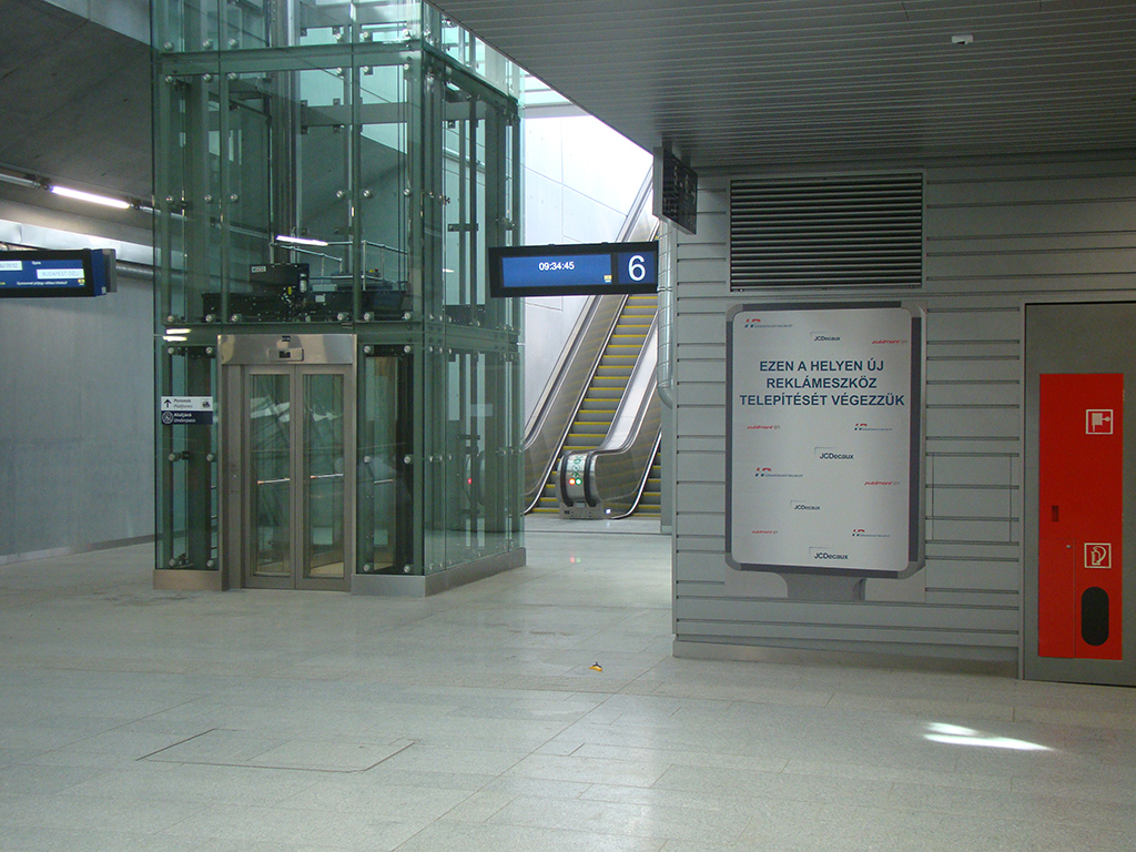 Lamellás „vandál biztos” acél falburkolat változó sávszélességgel a Kelenföldi M4-es metróállomás közlekedő folyosóján